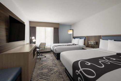 a hotel room with two beds and a television at La Quinta by Wyndham Savannah Airport - Pooler in Savannah