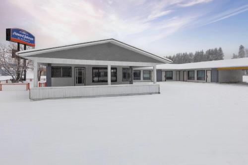 a building with a lot of snow in front of it at Howard Johnson by Wyndham Edson in Edson