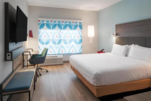 a hotel room with a bed and a desk and a television at Tru By Hilton Spring Hill in Spring Hill