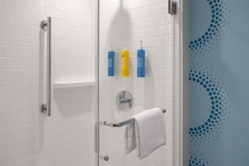 a bathroom with a shower with two shampoo bottles at Tru By Hilton Spring Hill in Spring Hill