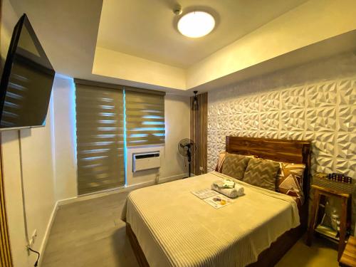 a bedroom with a bed and a window with blinds at Azure North Monaco 10F Pool View with Netflix and WiFi and Karaoke in San Fernando