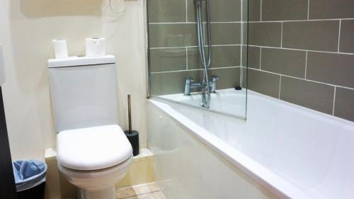 a bathroom with a toilet and a shower and a tub at Oban Hotel in Eastbourne
