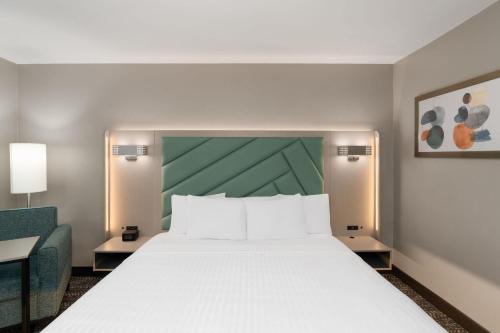 a bedroom with a large bed and a green wall at Wingate by Wyndham Jackson in Jackson