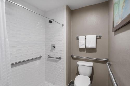 a bathroom with a toilet and a shower with towels at Wingate by Wyndham Jackson in Jackson