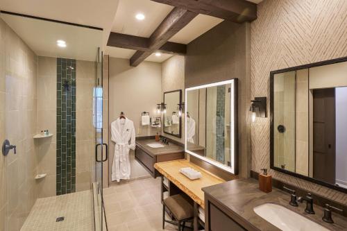 a bathroom with a shower and a sink and a mirror at Choctaw Landing Casino & Resort, Trademark Coll by Wyndham in Broken Bow
