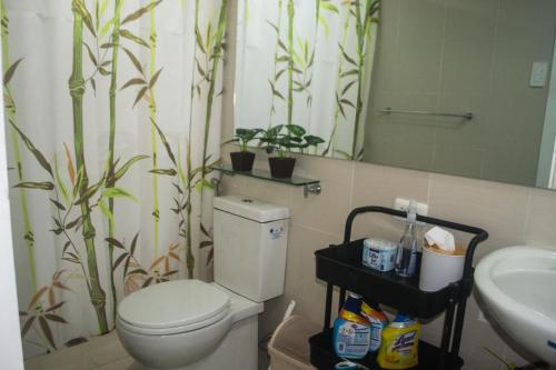 a bathroom with a toilet and a sink and a mirror at Azure North Monaco 10F Pool View with Netflix and WiFi and Karaoke in San Fernando