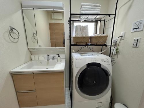 a laundry room with a washing machine and a sink at ev itoshima in Itoshima