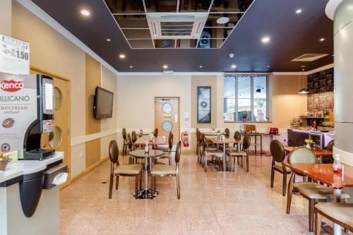 a dining room with tables and chairs in a restaurant at Eurotraveller Hotel - Premier - Harrow in Harrow