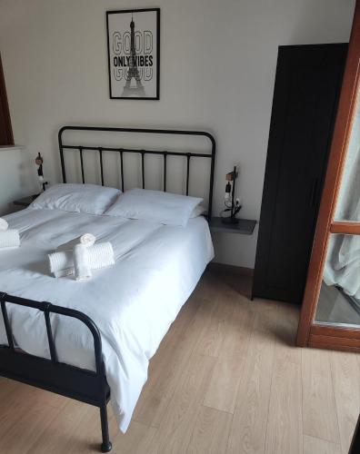 a bedroom with a white bed with a black frame at La Dimora di Alma in Clivio
