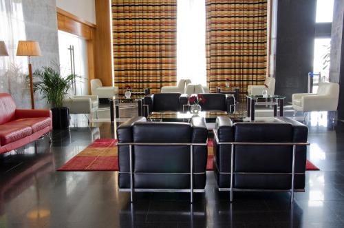 a lobby with chairs and a table in a building at VIP Executive Santa Iria Hotel in Santa Iria da Azóia