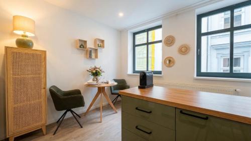 a room with a desk and chairs and windows at City Apartments in Rostock