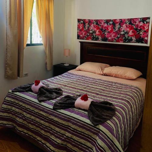 a bedroom with a bed with towels on it at Hostal y Cabañas Pua Vaenga in Hanga Roa