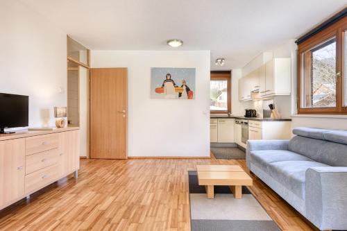 a living room with a couch and a kitchen at Gartenappartement Kirchdorf by A-Appartments in Brand