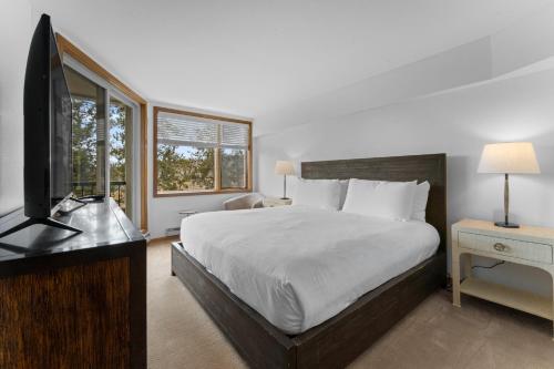 a bedroom with a bed and a desk and a television at Pines #2124 in Keystone