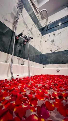 a room filled with red flowers on the floor at THE CHALET- Pondicherry, Near Eden Beach - BMC in Pondicherry