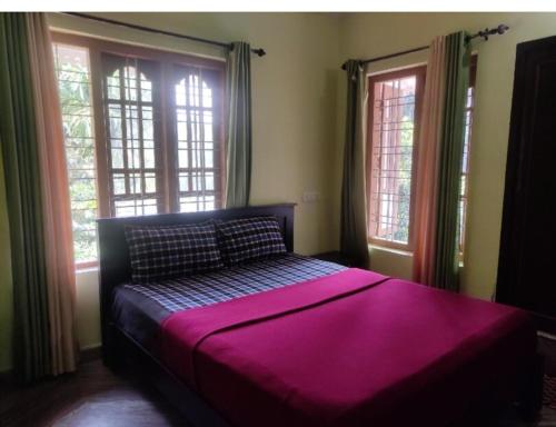 a bedroom with a purple bed with two windows at Golden cypress resort with pool in Vythiri