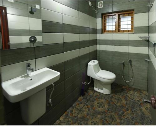 a bathroom with a sink and a toilet at Golden cypress resort with pool in Vythiri