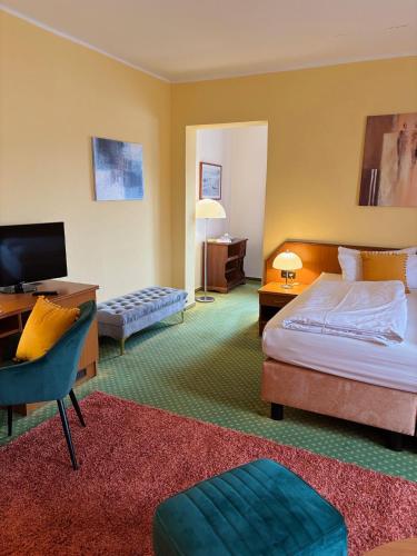 a hotel room with a bed and a desk and a television at Hotel Waldperle in Göhren