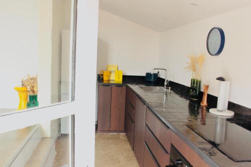 a kitchen with a sink and a counter with a mirror at L'Oustalet Arles in Arles