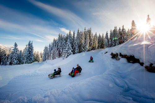a group of people riding down a snow covered slope at Pension Grafengut in Radstadt