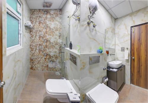 a bathroom with a shower and a toilet and a sink at Status By Hotel The Emporio in Ghaziabad