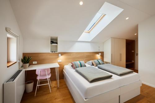 a bedroom with a white bed and a desk at Fine Rooms Vipava in Vipava
