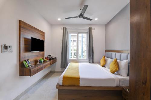 a bedroom with a large bed with a ceiling fan at Status By Hotel The Emporio in Ghaziabad
