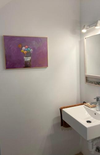 a bathroom with a sink and a painting on the wall at Puerto de Cala Ratjada in Cala Ratjada