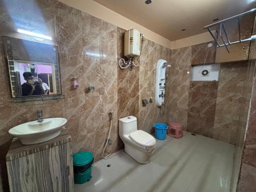 a bathroom with a toilet and a sink at Hotel Kep's - A Business Class Hotel in Contai