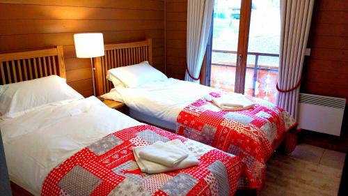 2 Betten in einem Zimmer mit einer Decke in der Unterkunft Apartment La Chapelle d'Abondance in La Chapelle-dʼAbondance