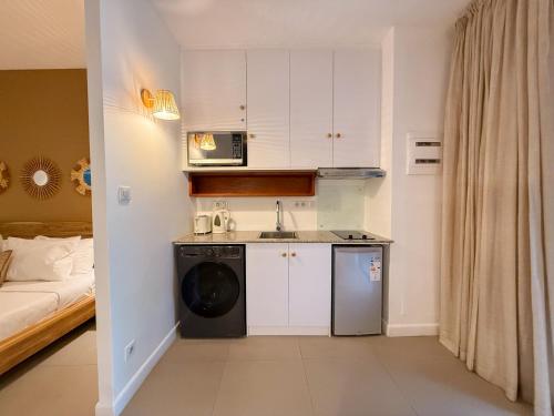 a small kitchen with a sink and a microwave at Be Cosy by LOV Mauritius in Trou aux Biches