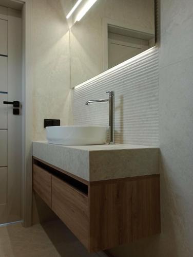 a bathroom with a sink and a mirror at Apartamenty Leszczynowa 7 blisko Zatora in Spytkowice