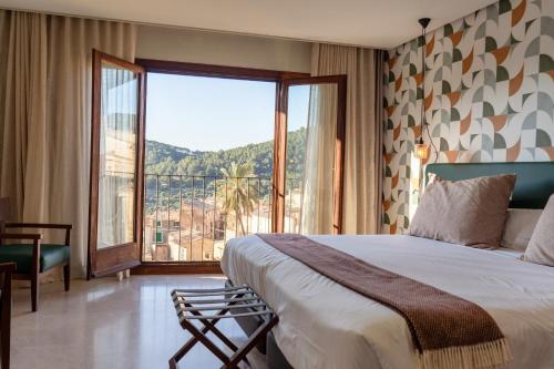 a bedroom with a large bed and a large window at Maristel Hotel & Spa - Adults Only in Estellencs