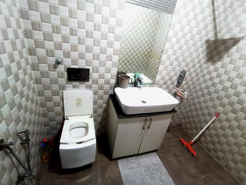 a bathroom with a white toilet and a sink at Hotel Vivara in Lucknow