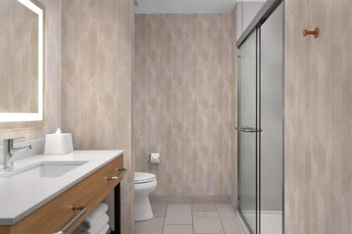 a bathroom with a toilet and a sink and a shower at Hampton Inn Crossville in Crossville