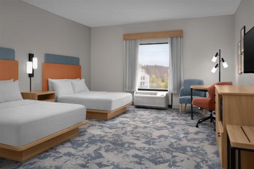 a hotel room with two beds and a desk at Hampton Inn Crossville in Crossville