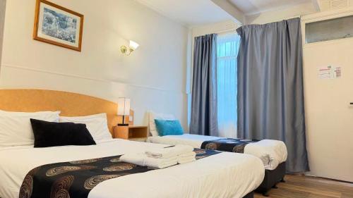 a hotel room with two beds and a window at Parkville Motel in Melbourne