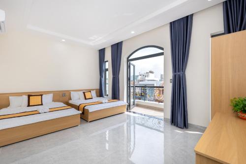 two beds in a room with a balcony at Villa 5 Lạc Long Quân - Bãi Sau in Vung Tau