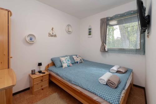 a small bedroom with a bed and a window at PART II apartman in Tiszaug