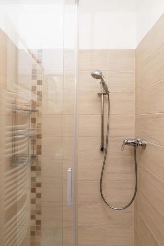a shower in a bathroom with a glass door at PART II apartman in Tiszaug