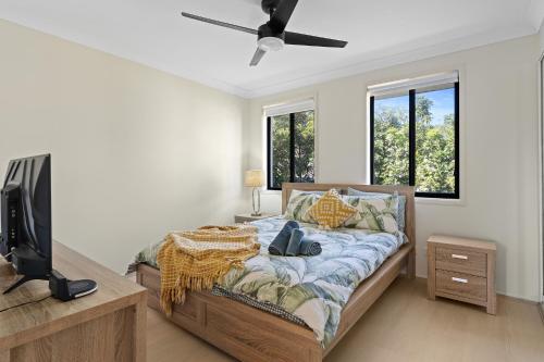 a bedroom with a bed and a flat screen tv at Hawks Nest Hideaway | Spa, BBQ, Bikes & Pool Table in Hawks Nest