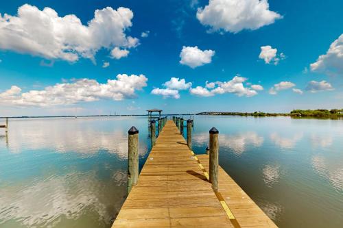 a wooden dock on a lake with clouds in the sky at 3424 Indian River Dr Main in Cocoa