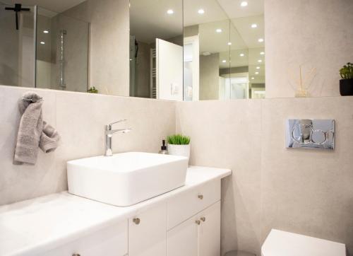 a white bathroom with a sink and a mirror at Casa Mary Aegina in Egina