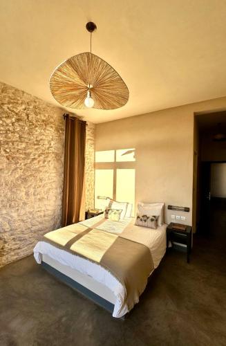 a bedroom with a large bed and a chandelier at Villa Azir in Ghazoua
