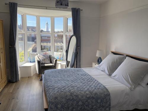 a bedroom with a bed and a chair and a window at 46 The Promenade in Withernsea