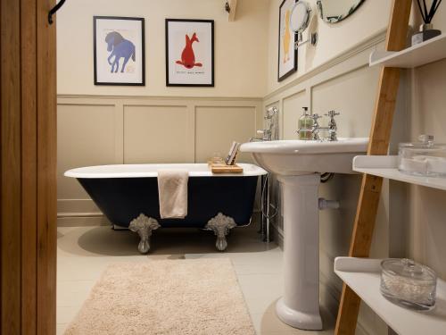 a bathroom with a bath tub and a sink at The Old Coach House in Alnwick