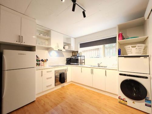 a kitchen with white cabinets and a washer and dryer at Spacious Guest Room 7 Sleeps 5 Near Shops with Free Parking in Highett