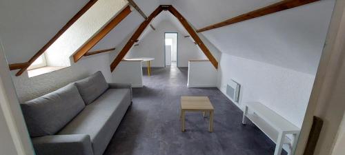 a living room with a couch and a table at Studio avec vu sur le Loir in La Flèche