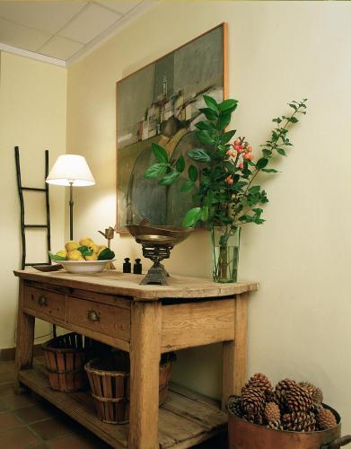 a table with a vase of flowers and a painting at Hotel L'Estació in Bocairent