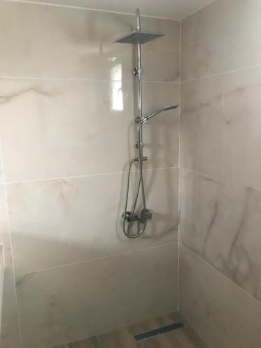 a shower in a bathroom with white tile at Maison de roche in Sozopoli